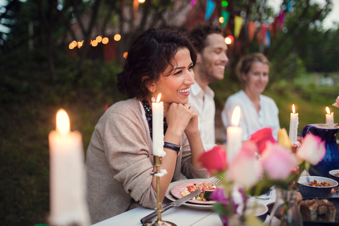 Women at dinner table laughing with others enjoying delicous food
